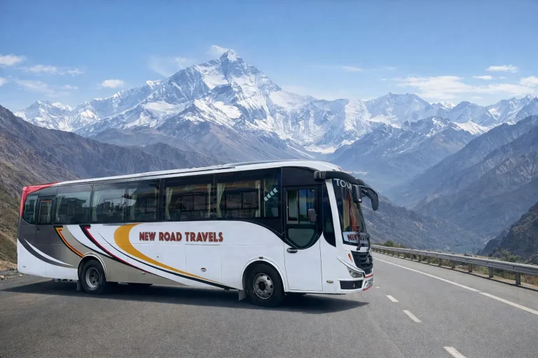 Newly constructed road winding through the Himalayan mountains with Mount Everest in the background under a clear blue sky.