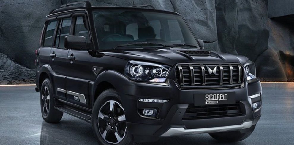 Mahindra Scorpio SUV car rental in Pokhara parked on a scenic road with mountain backdrop, ideal for hill and off-road travel.