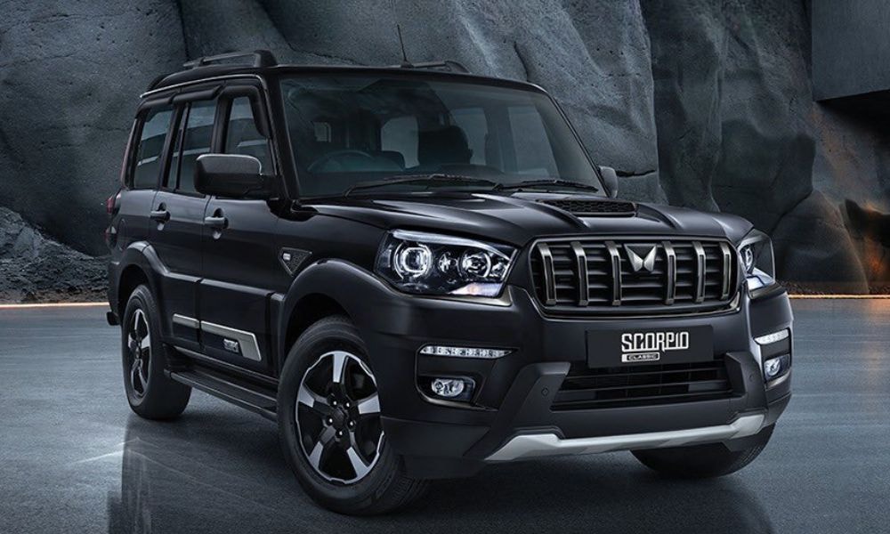 Mahindra Scorpio SUV car rental in Pokhara parked on a scenic road with mountain backdrop, ideal for hill and off-road travel.